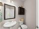 Small powder room featuring an oval sink, toilet, mirror, and dark cabinet at 275 Creek View Place, Canton, GA 30114
