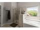 Bright bathroom featuring a tiled shower, soaking tub with tile surround, and a large window at 275 Creek View Place, Canton, GA 30114