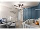 Bedroom featuring an accent wall, crib, changing table, and comfortable seating area at 275 Creek View Place, Canton, GA 30114