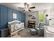 Bedroom featuring a wood accent wall, stylish crib, and a comfortable gray armchair at 275 Creek View Place, Canton, GA 30114