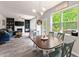 Open-concept room with dining area with view, fireplace, tv, and blue sectional sofa at 275 Creek View Place, Canton, GA 30114