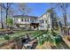 Back exterior view of home featuring a wooden deck, steps, and lush garden with blooming white flowers at 3075 Superior Dr, Dacula, GA 30019