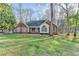 Charming brick home featuring mature trees and a well-manicured lawn on a sunny day at 3075 Superior Dr, Dacula, GA 30019