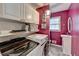 Laundry room with washer and dryer, shelves, and sink in room with deep pink walls at 3075 Superior Dr, Dacula, GA 30019