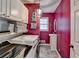 Laundry room with washer and dryer, shelves, and sink in room with deep pink walls at 3075 Superior Dr, Dacula, GA 30019