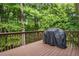 Wooden deck with dark-stained wooden planks and railing, with view of surrounding trees at 3962 Coventry Park Ln, Peachtree Corners, GA 30096