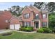 Charming two-story brick home featuring a well-manicured lawn and a two-car garage at 3962 Coventry Park Ln, Peachtree Corners, GA 30096