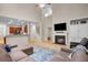 Open-concept living room with a fireplace, a TV, a ceiling fan, and a view of the staircase and kitchen at 3962 Coventry Park Ln, Peachtree Corners, GA 30096