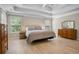 Main bedroom with a tray ceiling, ceiling fan, and hardwood floors, complemented by natural light from two windows at 3962 Coventry Park Ln, Peachtree Corners, GA 30096