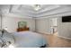 Bright main bedroom featuring a tray ceiling, a ceiling fan, hardwood floors, and a dresser at 3962 Coventry Park Ln, Peachtree Corners, GA 30096