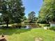 Private backyard pond, grassy lawn and abundant trees create a tranquil outdoor living space at 485 Angham Rd, Hiram, GA 30141