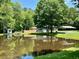 Scenic pond view with a charming shed and bridge adds tranquility to the backyard at 485 Angham Rd, Hiram, GA 30141
