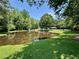 Scenic pond view surrounded by lush greenery and trees, creating a serene and picturesque setting at 485 Angham Rd, Hiram, GA 30141