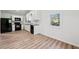 Spacious kitchen with white cabinets, black appliances, and wood-style floors at 5153 Westbrook Pl, Union City, GA 30291
