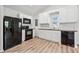 Well-lit kitchen with black appliances, white cabinets, and wood-look flooring at 5153 Westbrook Pl, Union City, GA 30291