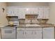 Kitchen showing white cabinets, granite countertops, modern appliances, and stainless sink at 6700 Roswell Rd # 22B, Atlanta, GA 30328