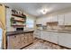 Well-lit kitchen featuring white cabinetry, granite countertops, and stylish floating shelves at 6700 Roswell Rd # 22B, Atlanta, GA 30328