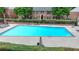 A community swimming pool with lounge chairs, greenery and surrounding condo buildings in the background at 6700 Roswell Rd # 22B, Atlanta, GA 30328