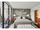 A tranquil main bedroom featuring a queen size bed with a decorative mural wall and a private balcony at 1130 Piedmont Ne Ave # 709, Atlanta, GA 30309