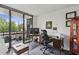 Bright home office features a desk, comfortable chair, and a sliding door to a patio with city views at 1130 Piedmont Ne Ave # 709, Atlanta, GA 30309