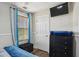 Bright bedroom featuring a TV, dresser with underlighting, and natural light from the window at 1221 Fountain Head Ct, Lawrenceville, GA 30043