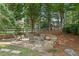 Tranquil backyard with stone patio and firepit, framed by mature trees and lush greenery at 1820 Hunters Moon Dr, Alpharetta, GA 30005