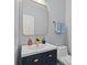 Stylish powder room featuring a modern vanity with gold hardware and a framed mirror at 1820 Hunters Moon Dr, Alpharetta, GA 30005
