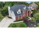 Elevated view of a brick house with a well-manicured lawn and a driveway leading to the garage at 1820 Hunters Moon Dr, Alpharetta, GA 30005