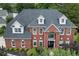 Stately brick home featuring a symmetrical facade, dormer windows and manicured landscaping at 1820 Hunters Moon Dr, Alpharetta, GA 30005