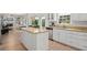 Bright kitchen features an island with a stone countertop, white cabinetry, and stainless steel appliances at 1820 Hunters Moon Dr, Alpharetta, GA 30005