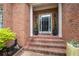 Elegant front door with sidelights, potted plants, and classic brick surround at 35 Kenmare Hall Ne, Atlanta, GA 30324