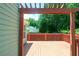 View of a wooden backyard deck with an overhead trellis and a view of the surrounding wooded area at 4016 Meadow Glen Way, Fairburn, GA 30213