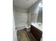Well-lit bathroom featuring a tub/shower combination, dark vanity, and wood-look flooring at 4016 Meadow Glen Way, Fairburn, GA 30213