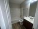 This bathroom offers a combination tub/shower, sleek vanity, and wood look vinyl flooring at 4016 Meadow Glen Way, Fairburn, GA 30213