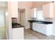 Well-lit kitchen featuring white cabinetry, dark countertops, and stainless steel appliances for a modern look at 4016 Meadow Glen Way, Fairburn, GA 30213