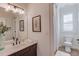 Bathroom featuring a single sink vanity, framed art, with a view into the toilet and shower at 4809 Highland Point Dr, Auburn, GA 30011