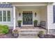 Inviting front porch featuring stone steps, elegant planters, and a welcoming entrance with stylish lanterns at 4809 Highland Point Dr, Auburn, GA 30011