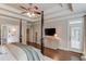 Main bedroom with tray ceilings, television on cabinet, and a door leading to the outdoor patio at 4809 Highland Point Dr, Auburn, GA 30011