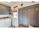 Mudroom with gray storage cabinets, decoratively tiled floor, hooks, and a woven window shade at 4809 Highland Point Dr, Auburn, GA 30011