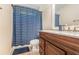 This bathroom features a wooden vanity, a large mirror, and patterned shower curtain at 220 Windpher Rdg, Hampton, GA 30228