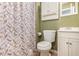 A neutral bathroom with a toilet, vanity, and shower with patterned curtain at 220 Windpher Rdg, Hampton, GA 30228