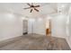 Large carpeted bedroom featuring a tray ceiling, ceiling fan, and multiple doors at 220 Windpher Rdg, Hampton, GA 30228