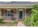 Close-up of the charming brick front porch with white railings and rocking chair at 220 Windpher Rdg, Hampton, GA 30228