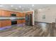 Open kitchen with stainless steel appliances, wood cabinets, and modern flooring at 220 Windpher Rdg, Hampton, GA 30228