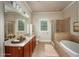 Luxurious bathroom featuring a soaking tub, glass shower, dual sinks, and ample counter space at 2300 Peachford Rd # 3411, Dunwoody, GA 30338
