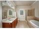 Elegant bathroom showcasing a soaking tub, glass shower, dual sinks, and a well-lit vanity area at 2300 Peachford Rd # 3411, Dunwoody, GA 30338