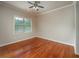 Well-lit bedroom with hardwood floors, neutral walls, ceiling fan, and a large window at 2300 Peachford Rd # 3411, Dunwoody, GA 30338