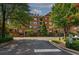 Exterior view of a traditional brick condo building featuring manicured lawns at 2300 Peachford Rd # 3411, Dunwoody, GA 30338