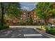 Attractive brick building surrounded by lush trees and manicured lawns, enhancing curb appeal at 2300 Peachford Rd # 3411, Dunwoody, GA 30338