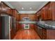 Galley kitchen with stainless steel appliances, granite countertops, and cherry wood cabinets at 2300 Peachford Rd # 3411, Dunwoody, GA 30338